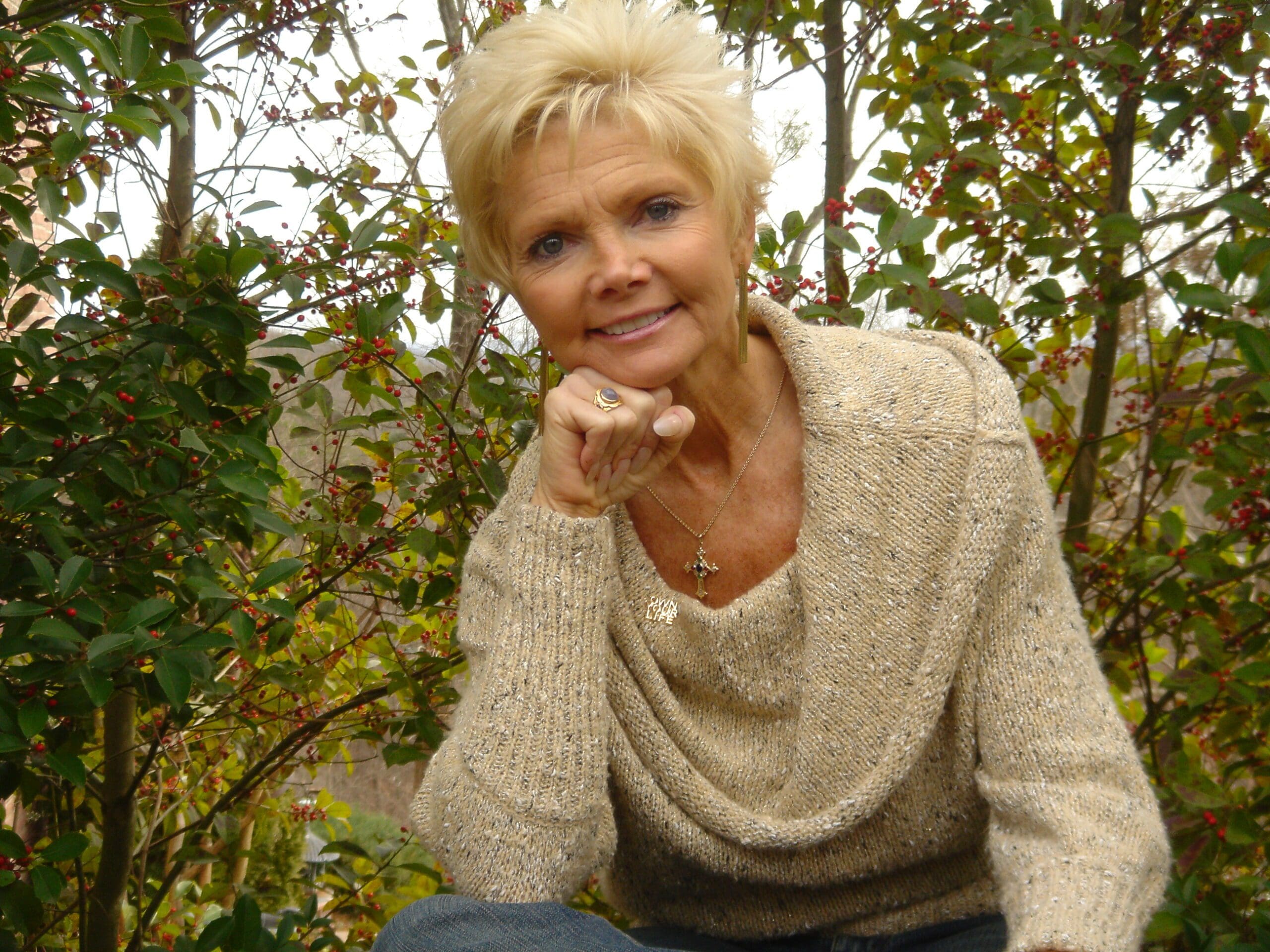 A woman sitting in front of some trees