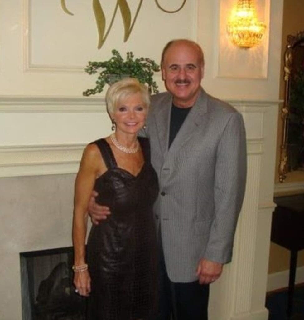 AN elder couple standing together and posing for a picture.